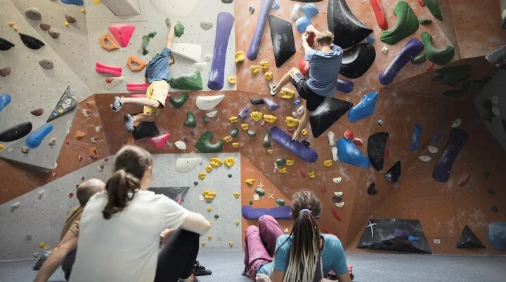 In der Boulderhalle: Ansicht einer Boulderwand mit Sportlern | © DAV / Jens Klatt